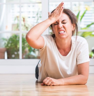 Orta yaşlı kadın elle kafasına, utanç ve sürpriz yüz ile şok vurguladı öfkeli ve sinirli. Korku ve hata için üzgün.