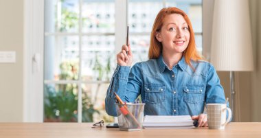 Kızıl saçlı kadın bir fikir ya da soru işaret parmağı gülen yüz, bir numara ile sürpriz evde eğitim