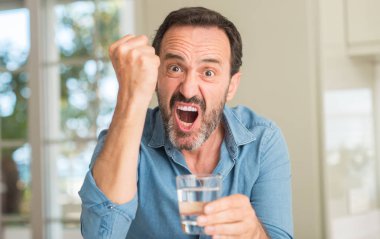 Bir bardak su rahatsız ve öfke, çılgın ve yükseltilmiş el, öfke kavramı ile diye bağıran ile sinirli bağırarak içme orta yaş erkek