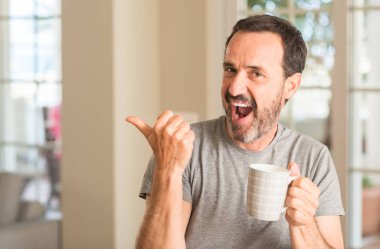 El ve parmak ile yukarı dönük mutlu yüz gülümseyen ile bir fincan kahve içme orta yaş erkek