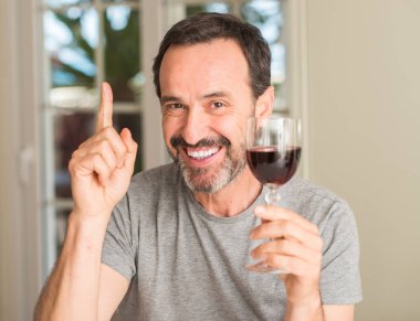 Bir kadeh şarap bir fikirle sürpriz içmek yaş adam orta veya gülen yüz, bir numara ile işaret parmağı soru