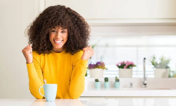 美丽的非洲裔美国妇女拿着一杯咖啡在家里尖叫着自豪和庆祝胜利和成功非常兴奋 欢呼的情绪 — 图库照片
