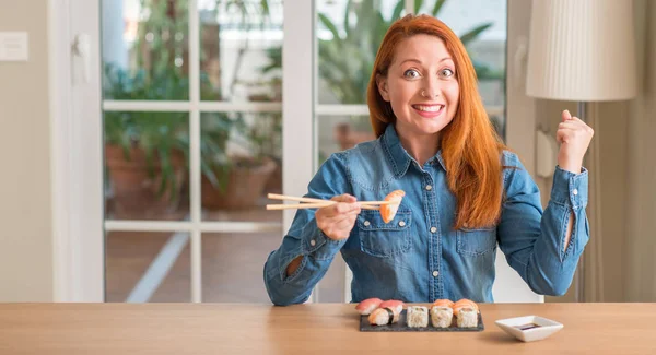 Redhead Woman Eating Sushi Using Chopsticks Screaming Proud Celebrating Victory — Stock Photo, Image