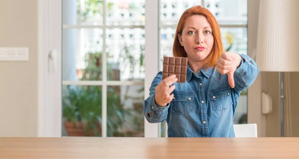 Mulher Ruiva Segurando Barra Chocolate Casa Com Rosto Irritado Sinal — Fotografia de Stock