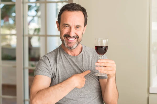 Middle Age Man Drinking Glass Wine Surprise Face Pointing Finger — Stock Photo, Image