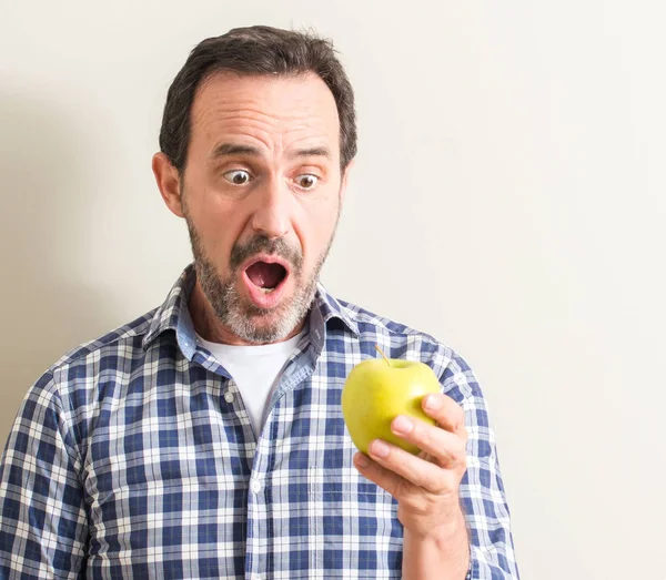 Hombre Mayor Sosteniendo Una Manzana Verde Asustado Shock Con Una — Foto de Stock