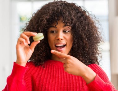 Macaron çok mutlu el ve parmak ile işaret tutan Afrikalı-Amerikalı kadın