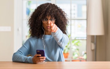 Kamera ve size, el işareti, pozitif ve kendinden emin bir jest ön parmak ile işaret smartphone kullanarak güzel bir Afrikalı-Amerikalı kadın