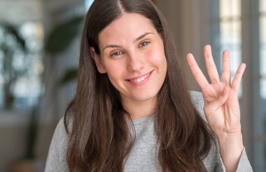 Genç güzel kadın evde gösterilen ve parmak dördüncü gülümseyen ise kendinden emin ve mutlu yukarı dönük.