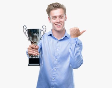 Genç yakışıklı sarışın adam el ve parmak ile yukarı dönük mutlu yüz gülümseyen ile bir kupa holding