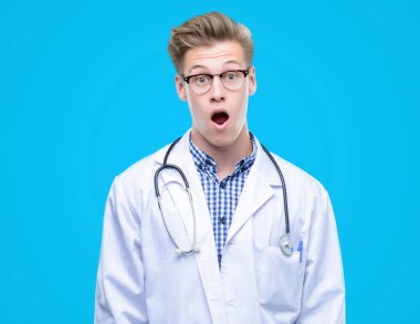 Genç yakışıklı sarışın doktor bir sürpriz yüz, korkuyor ve heyecanlı korku ifadesi ile şok korkmuş