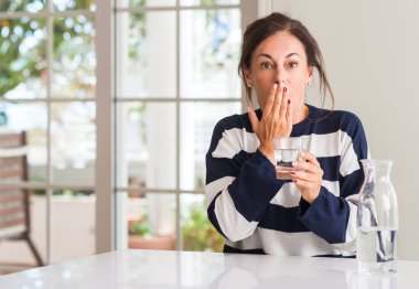 Orta yaşlı kadın su kapak ağız şok utançla hata, korku, ifade için el ile bir bardak içme sessizlik içinde gizli kavramı korkuttu