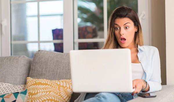 Νεαρή Όμορφη Γυναίκα Σοκ Πρόσωπο Χρησιμοποιώντας Laptop Στον Καναπέ Ψάχνει — Φωτογραφία Αρχείου
