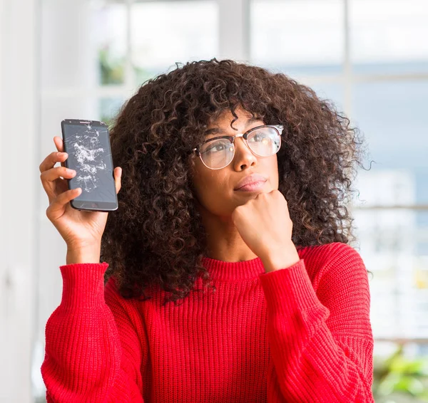 Kırık smartphone ciddi bir yüz düşünme hakkında soru, çok karışık fikir tutan Afrikalı-Amerikalı kadın