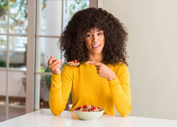 非洲裔美国妇女吃谷物 覆盆子和蓝莓非常高兴地指着手和手指 — 图库照片