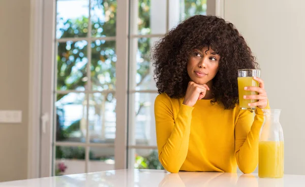 非洲裔美国妇女饮用健康果汁在家中严肃的面孔思考问题 非常困惑的想法 — 图库照片