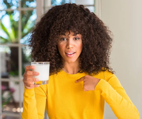 Африканская Американка Держит Стакан Молока Удивленным Лицом Указывающим Пальцем Себя — стоковое фото