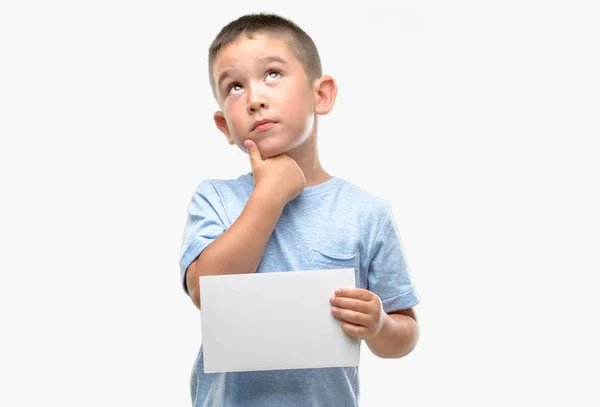 Criança Cabelos Escuros Segurando Cartão Branco Rosto Sério Pensando Questão — Fotografia de Stock