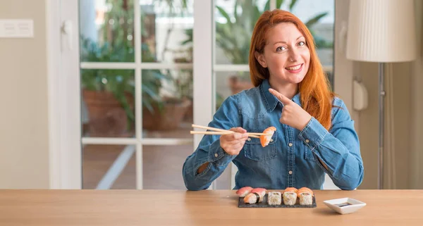 Redhead Woman Eating Sushi Using Chopsticks Very Happy Pointing Hand — Stock Photo, Image
