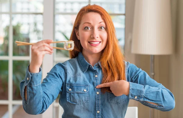 Redhead Woman Eating Sushi Using Chopsticks Surprise Face Pointing Finger — Stock Photo, Image