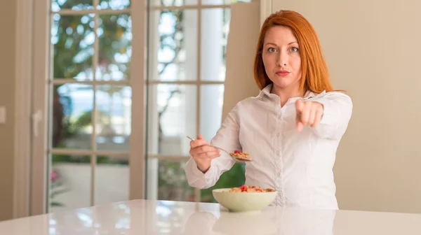 Rödhårig Kvinna Äta Spannmål Med Hallon Hemma Pekar Med Fingret — Stockfoto