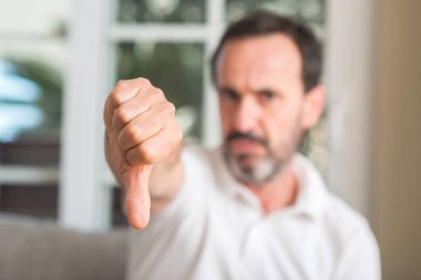 Yakışıklı orta yaş adam kızgın yüzü, eksi işareti aşağı antipati başparmak ile gösterilen, ret kavramı ile