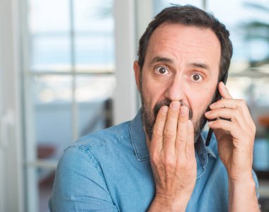 Sessizlik, gizli kavramı için hata, ifade korku, utanç ile şok el ile Smartphone kapak ağız kullanan orta yaş adam korkuttu