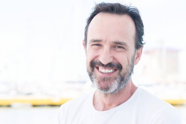 Yelkenli üzerinde seyahat ve mutlu ve kendinden emin gülümseyen kıdemli yakışıklı