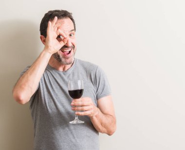 Komuta sizde mutlu yüz el parmaklarının arasından seyir göz üzerinde ok işaretiyle yapıyor gülümseyen ile bir bardak kırmızı şarap içme