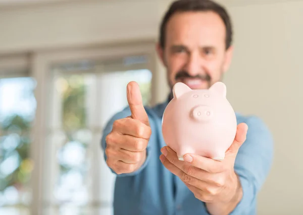 Mężczyzna Średnim Wieku Zaoszczędzić Pieniądze Piggy Bank Szczęśliwy Uśmiechem Robi — Zdjęcie stockowe