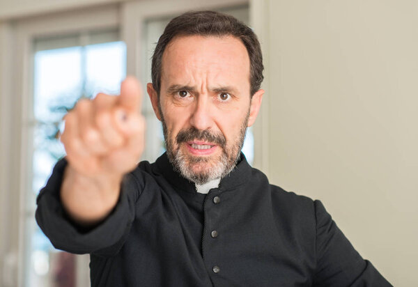 Christian priest man pointing with finger to the camera and to you, hand sign, positive and confident gesture from the front