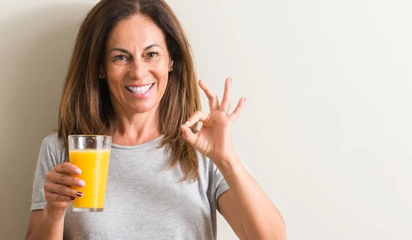 Medelålders Kvinna Dricker Apelsinjuice Ett Glas Gör Tecken Med Fingrarna — Stockfoto