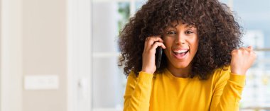 Afrikalı-Amerikalı kadın gurur çığlık ve zafer ve başarı çok heyecanlı, kutluyor smartphone kullanarak duygu tezahürat