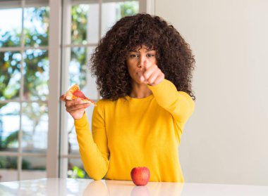 Afrikalı-Amerikalı kadın apple ve kamera ve size, el işareti, pozitif ve kendinden emin bir jest ön dilim pizza parmak ile işaret arasında seçme