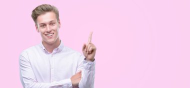 Genç yakışıklı sarışın adam el ve parmak ile tarafına işaret çok mutlu