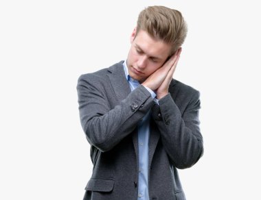 Genç yakışıklı sarışın iş adamı uyku yorgun hayal ve ile gülümseyen gözleri kapalı iken ellerle birlikte poz.