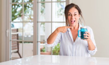 El ve parmak ile işaret çok mutlu bir bardak muzlu süt içme orta yaşlı kadın