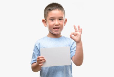 Koyu saçlı küçük çocuk parmak, mükemmel sembolü ile ok işareti yapıyor boş bir kart tutan