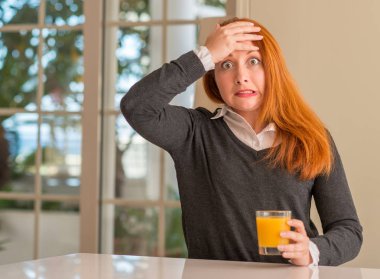 Portakal suyu cam evde, baş, el ile vurguladı tutan Kızıl saçlı kadın şok utanç ve sürpriz suratla, öfkeli ve sinirli. Korku ve hata için üzgün.