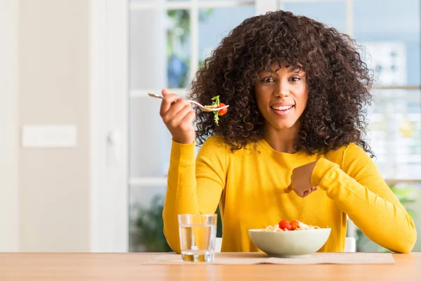Africká Americká Žena Jíst Těstoviny Salát Doma Překvapením Tvář Ukazováčkem — Stock fotografie