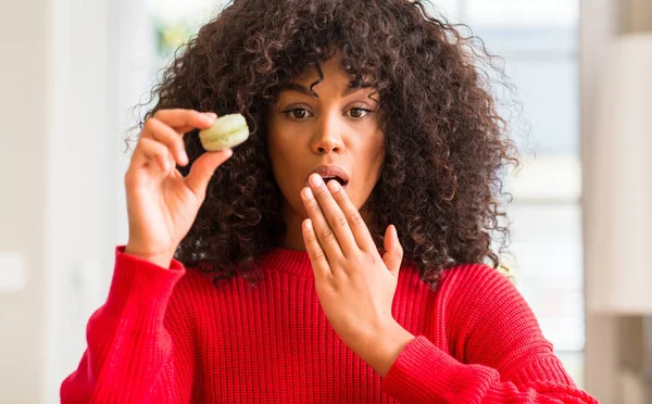 Mujer Afroamericana Sosteniendo Boca Cubierta Macaron Con Mano Conmocionada Por —  Fotos de Stock