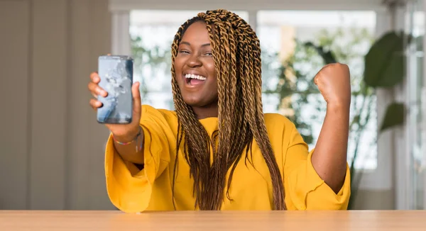 Afrikalı-Amerikalı kadın gurur çığlık ve zafer ve başarı çok heyecanlı, kutluyor kırık smartphone gösterilen duygu tezahürat