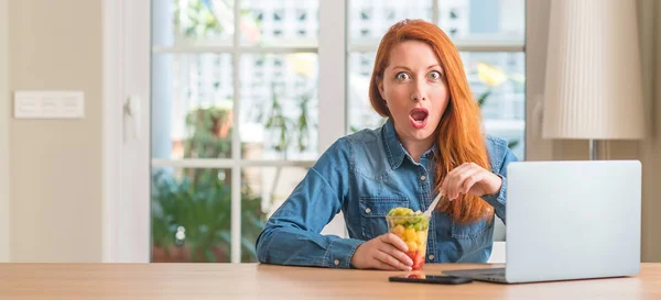 Mulher Ruiva Usando Laptop Computador Comendo Frutas Casa Assustada Choque — Fotografia de Stock