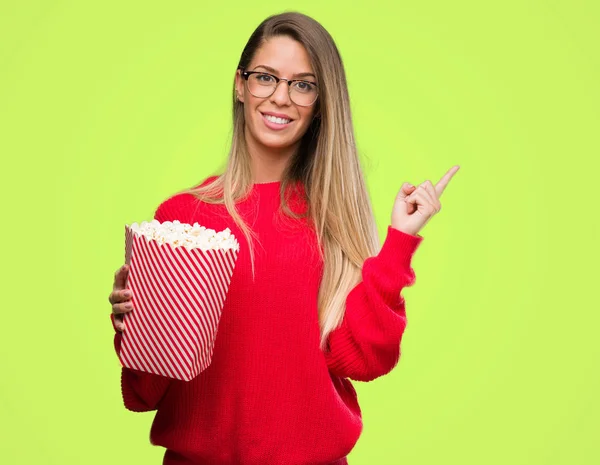 Mulher Bonita Comendo Pipocas Muito Feliz Apontando Com Mão Dedo — Fotografia de Stock