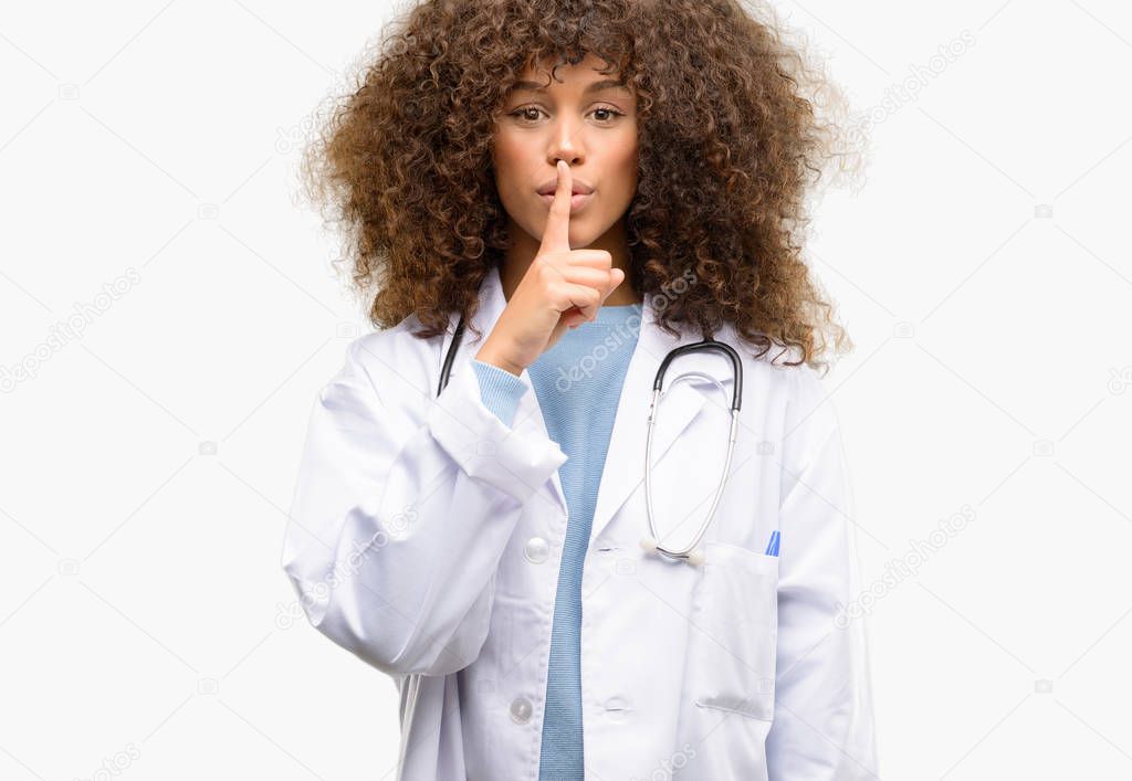 African american doctor woman, medical professional working with index finger on lips, ask to be quiet. Silence and secret concept