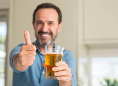 Ok işareti, başparmak ile parmak, mükemmel işareti yapıyor kocaman bir gülümseme ile mutlu bira içme orta yaş erkek