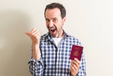 Komuta sizde İspanyol pasaportu el ve parmak ile yukarı dönük mutlu yüz gülümseyen ile tutarak