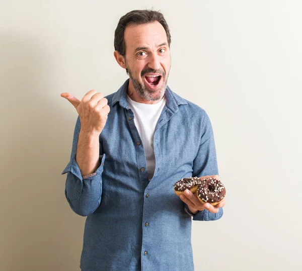 Komuta sizde el ve parmak ile yukarı dönük mutlu yüz gülümseyen ile çikolatalı çörek yeme