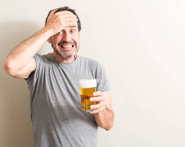 Старший Мужчина Пьет Пиво Напряжением Руки Голове Шоке Стыда Удивления — стоковое фото