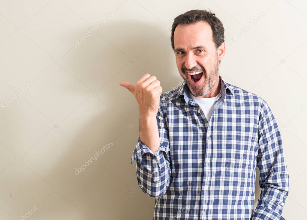 Senior man pointing with hand and finger up with happy face smiling